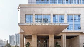The exterior of The Pearl Boutique Hotel with a modern facade, large windows, and a prominent entrance.