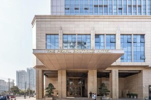 The exterior of The Pearl Boutique Hotel with a modern facade, large windows, and a prominent entrance.