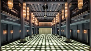 Un amplio y luminoso vestíbulo de hotel con un estampado de pisos a cuadros, varios balcones y grandes lámparas de araña.