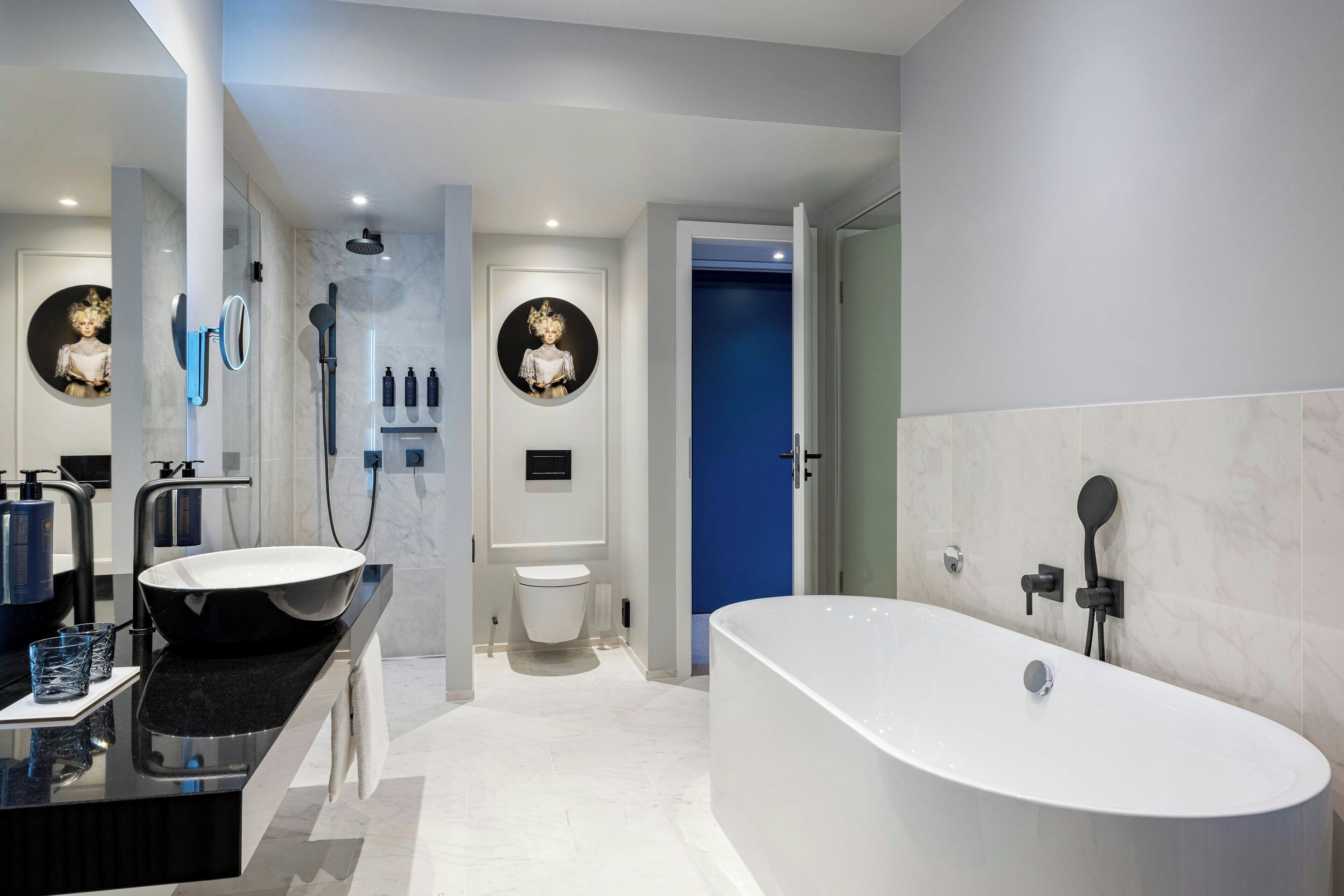 A modern bathroom with a freestanding bathtub, a vanity with a large sink, and a toilet.