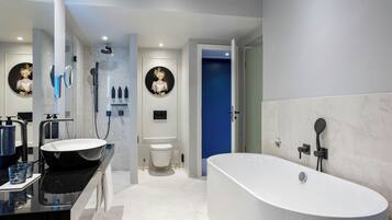 A modern bathroom with a freestanding bathtub, a vanity with a large sink, and a toilet.