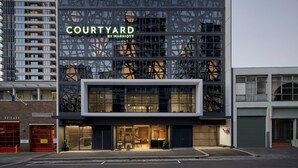 Moderni rakennus, jossa on kyltti, jossa lukee ”Courtyard by Marriott”, ja selvästi näkyvä sisäänkäynti.