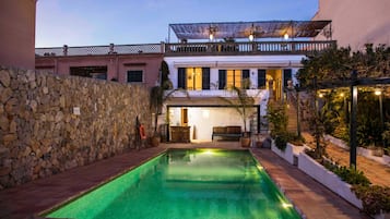Una piscina al aire libre de temporada, sombrillas, tumbonas