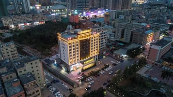 A multi-story hotel with a central courtyard, surrounded by other buildings.