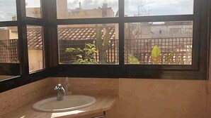 A bathroom with a sink and window. - Duplex (Lloret de Mar)