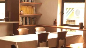A dining area with a table, chairs, and a bookshelf. - Duplex (Lloret de Mar)