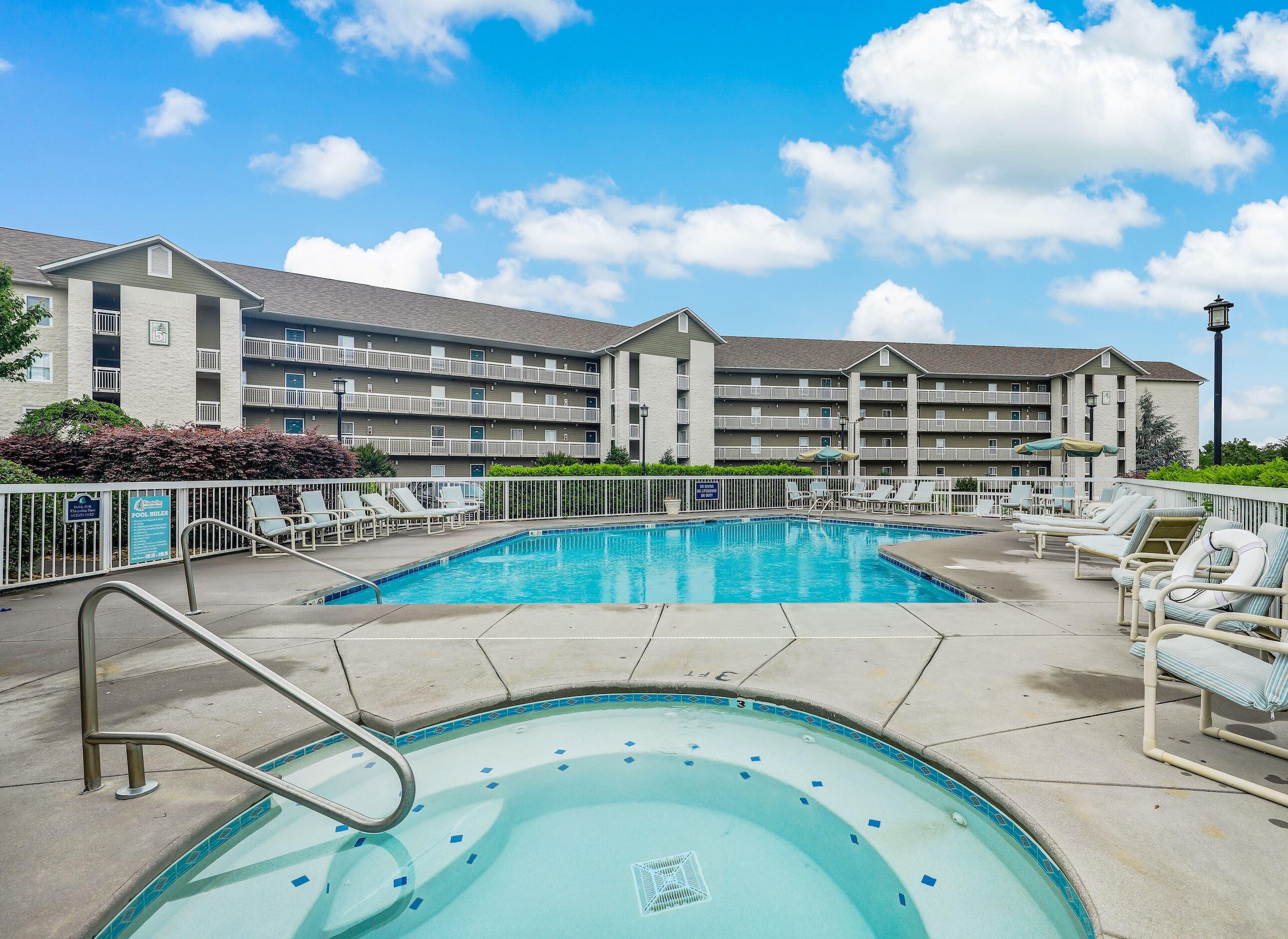 Ein Hotel mit Schwimmbad und Liegestühlen.