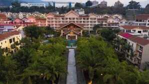 Un hôtel doté d’une cour intérieure, bordée de palmiers et agrémentée d’une piscine.
