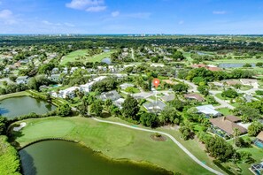 Stunning views of a residential area with a golf course, surrounded by lush greenery and serene water features.