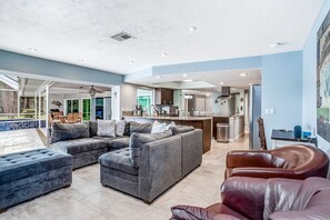 Relax in a spacious living area with a comfortable sofa and armchair, surrounded by an open and airy atmosphere.