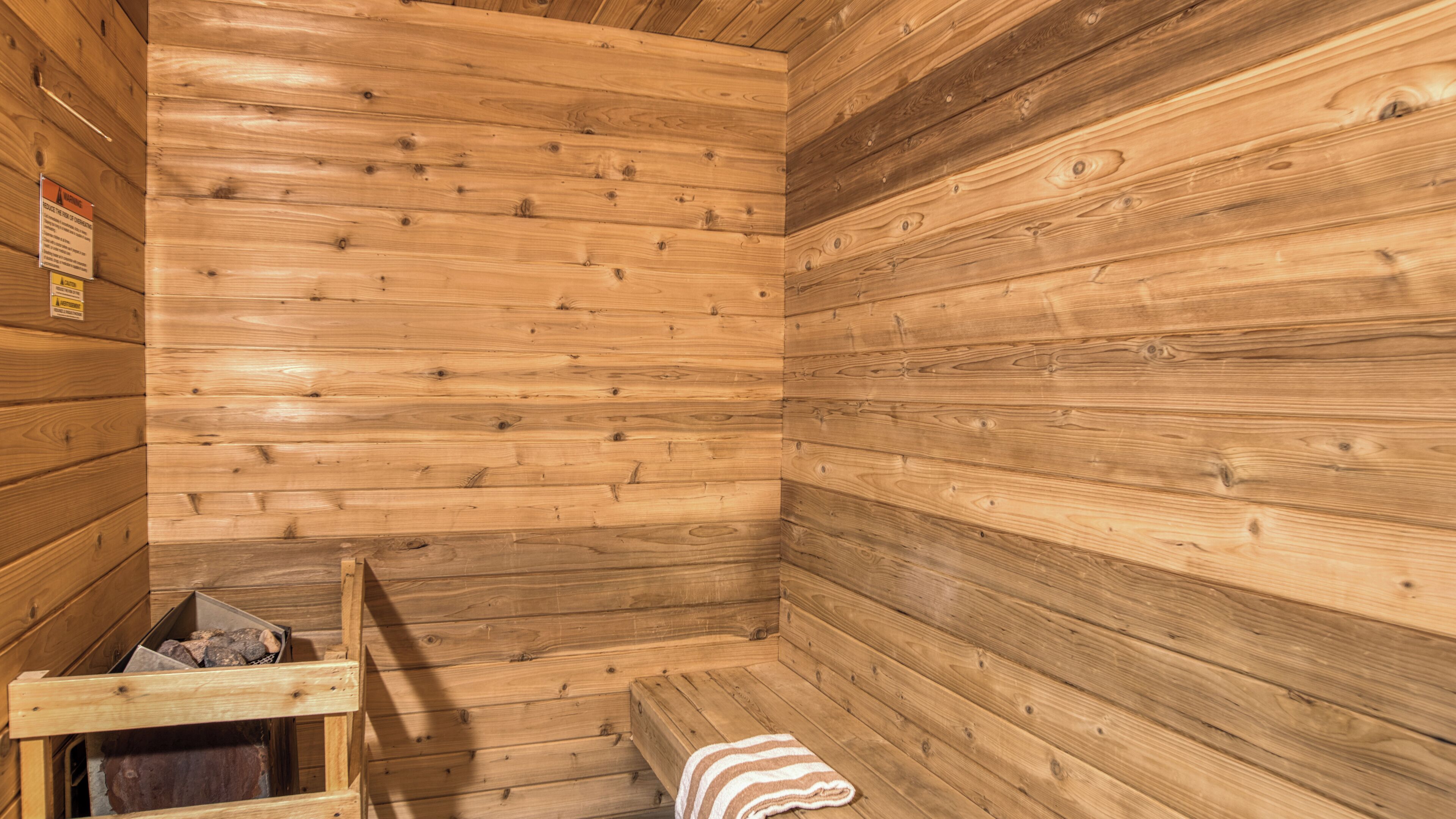 Un sauna de madera con bancos y una banca con una toalla.