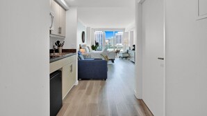 A modern apartment with a kitchen, a living area with a sofa, and a view of the city. - SF Beautiful Blue & Gold Studio with Ocean View (Miami)