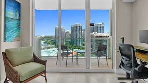 A modern room with a large sliding glass door leading to a balcony with a city view. - SF Amazing Studio - Walking Distance to Cocowalk (Miami)