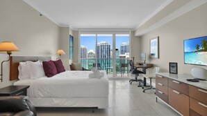 A modern hotel room with a large bed, a desk, a chair, and a TV. - SF Amazing Studio - Walking Distance to Cocowalk (Miami)