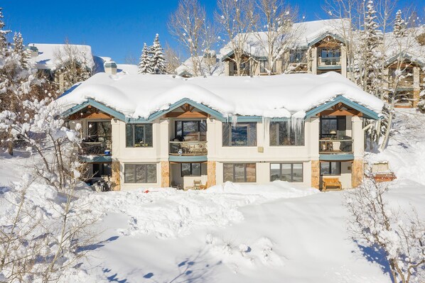 A large, multi-story building with a snow-covered roof and multiple balconies. - INS02 | Amazing View | Ski In/Out | Pool/Hot Tub | Winter Shuttle | Close to Mtn (Steamboat Springs)