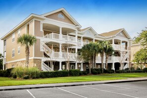Stunning multi-story building with a central entrance and two wings, each featuring a balcony with railings.
