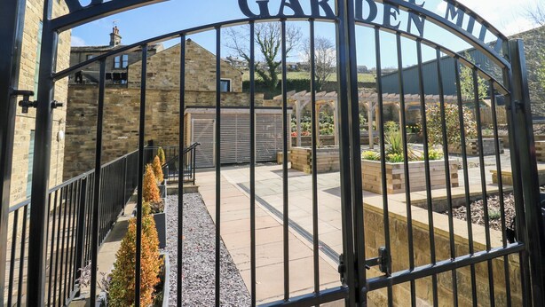 A metal gate with the words "Bridgehouse Garden Mill" engraved on it. - Over The Arch (Keighley)