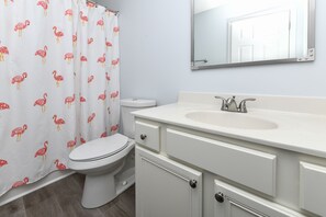 Ein Badezimmer mit Toilette, Waschbecken und Spiegel.