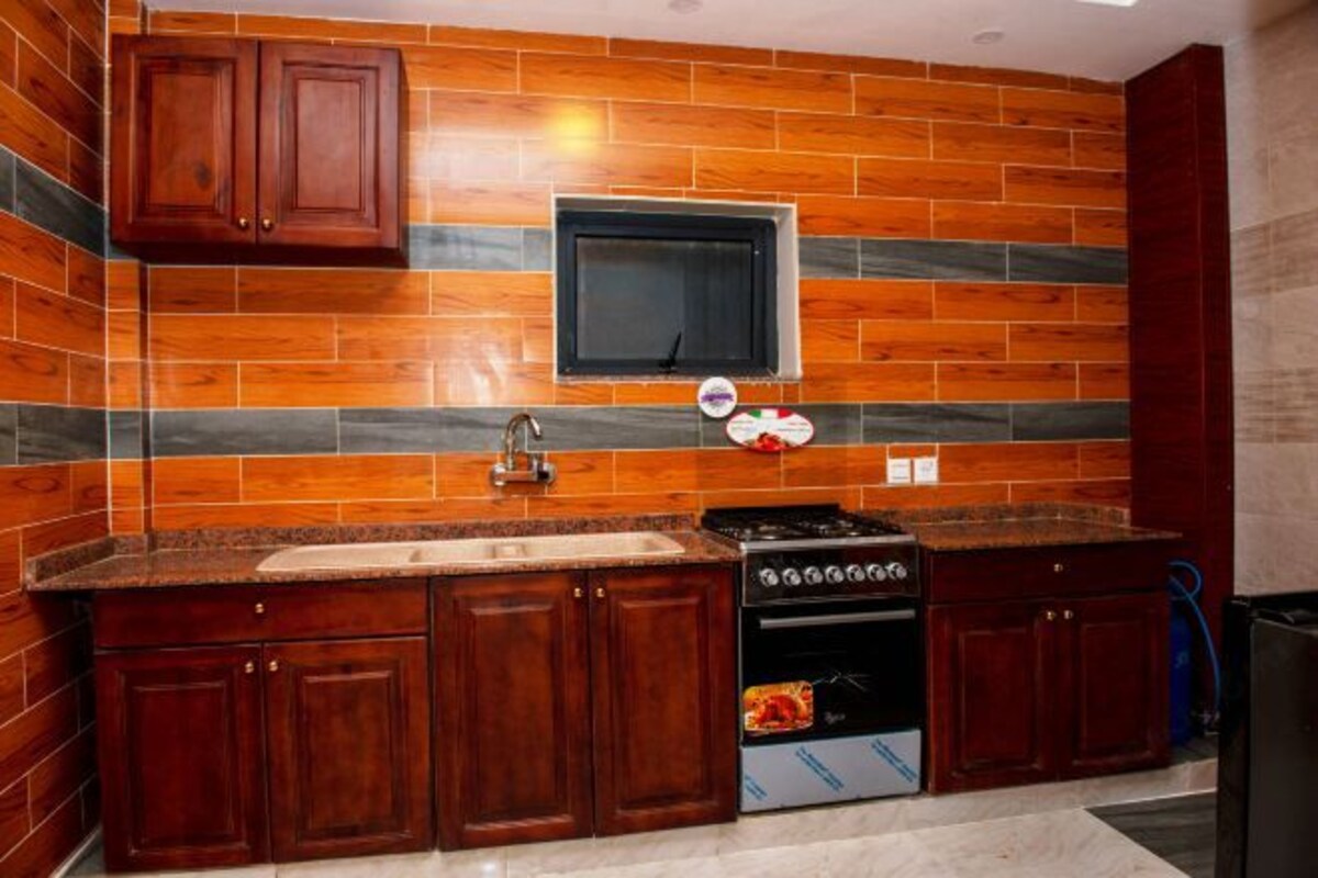 A kitchen with wooden cabinets, a stove, and a microwave.