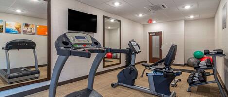 A gym with treadmills, an elliptical, and free weights.