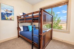 A bunk bed with a view of a desert landscape through a window. - Comfortable condo with indoor/outdoor pool (Hurricane)