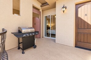 A barbecue grill, a sliding glass door, and a wooden door with the number 8.