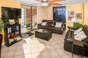 Relax in this stylish living room with a large flat-screen TV, leather sofa, and city views.