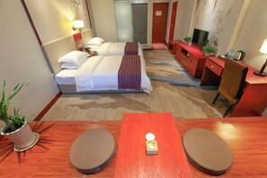 A hotel room with a bed, bedside tables, a TV, and a desk with a chair. - Bofei Hotel (Chongqing)