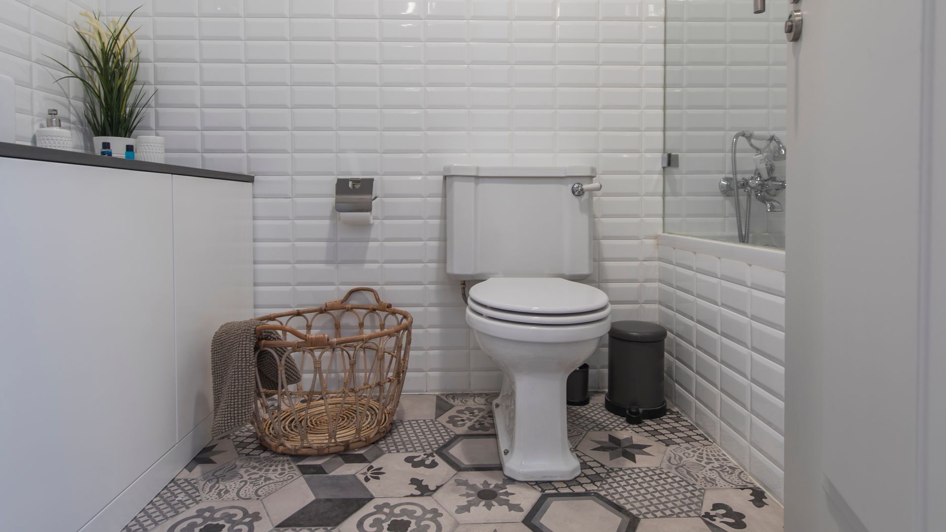 Un bagno piccolo con il water, un cestino e un cesto in vimini.