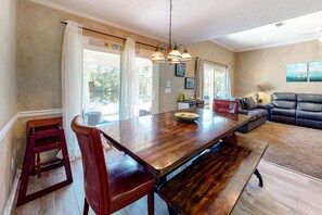 Relax in this stylish living room with a large dining table, comfortable sofa, and artwork on the walls.