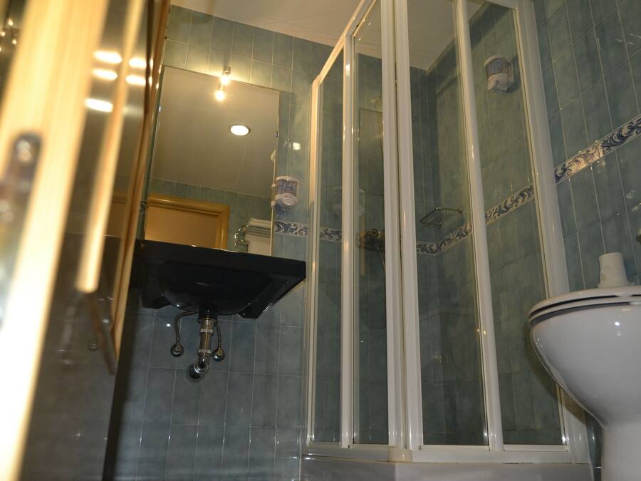 Une salle de bain avec une douche à parois de verre, un lavabo et des toilettes.
