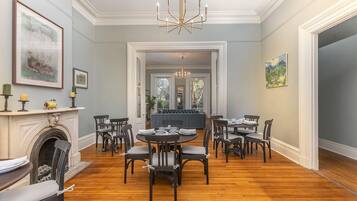 Comedor con chimenea, piso de madera y candelabro.