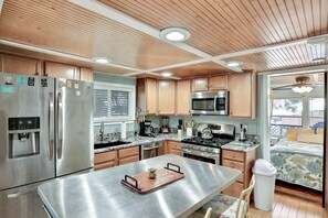 Enjoy cooking in this well-equipped kitchen with a central island, sink, and stainless steel appliances.