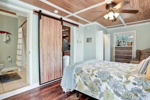 Relax in this serene bedroom with a large bed and sliding door to a bathroom.