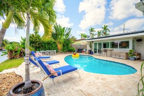 A swimming pool with lounge chairs, a palm tree, and a house with a satellite dish. - Waterfront 3BR • Heated Pool, Kayaks, Paddleboard • Quiet Family Friendly (Oakland Park)