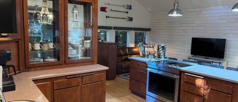 A modern kitchen with wooden cabinets, a stainless steel sink, and a built-in oven.