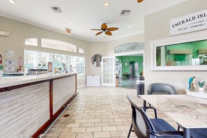 Welcome to Emerald Isle, where a spacious lobby awaits with a reception desk, seating area, and large windows.