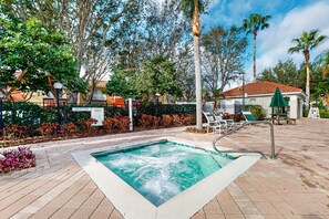 Relax by the pool surrounded by lush greenery and palm trees.
