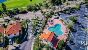 Vista aerea di un resort con piscina, area parcheggio e campo da golf.