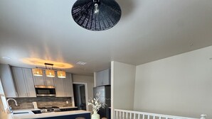 Una cocina moderna con armarios grises, un microondas negro y un horno de acero inoxidable.