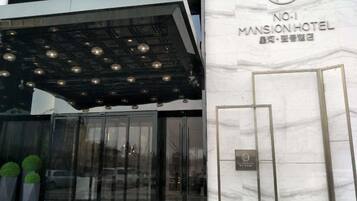 The exterior of No.1 Mansion Hotel with a modern entrance featuring glass doors and a metal canopy.
