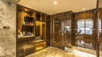 A bathroom with a marble floor, wooden vanity, and a mirror.