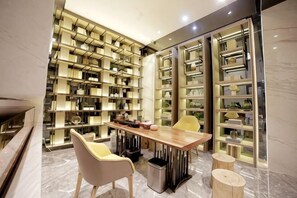 A modern library with bookshelves, a wooden table, and chairs.