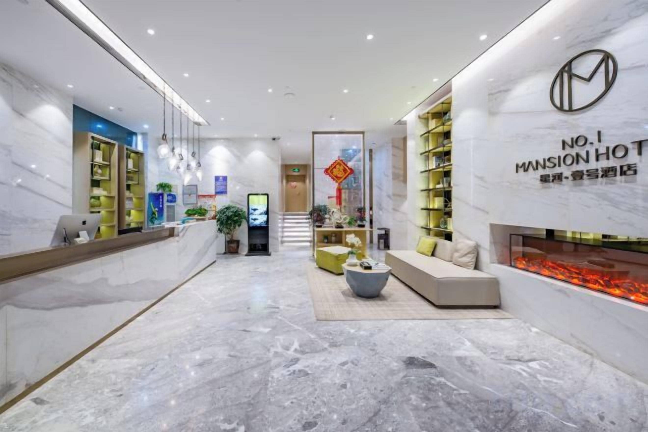 A hotel lobby with a reception desk, seating area, and a fireplace.