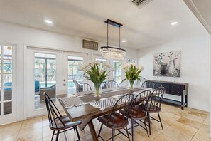 Enjoy meals in this dining area with a large table and six chairs, a chandelier, and a console table.