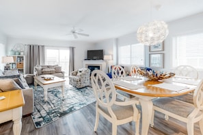 Relax in a spacious living room with a comfortable seating area, dining table for four, and a fireplace.
