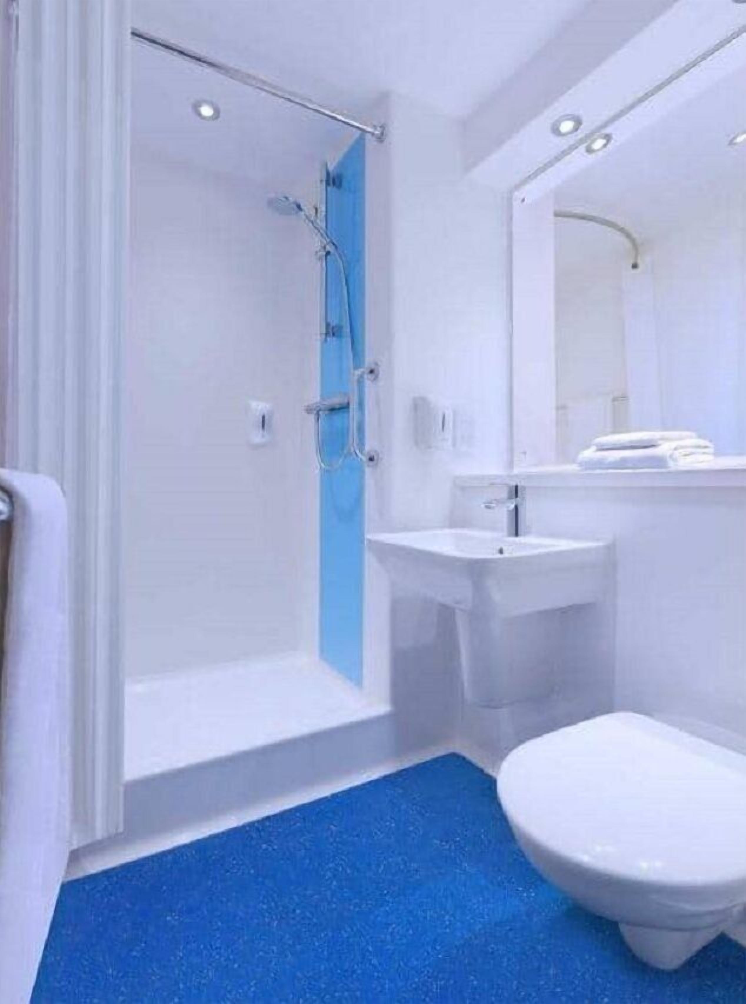 A bathroom with a shower, sink, and toilet.