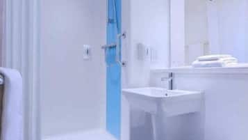 A bathroom with a shower, sink, and toilet.