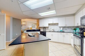 Enjoy cooking in this well-lit kitchen with an oven, dishwasher, and sink.