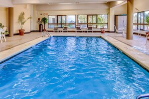 Relax by the serene pool surrounded by comfortable lounge chairs and lush greenery.